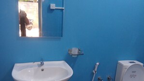 A bathroom with a sink, toilet, and a mirror. -  Amaya Hotel and Restaurant (Dikwella)