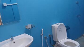 Un baño con un lavabo blanco, un inodoro y una pared azul.