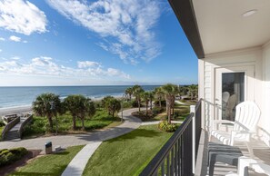 A balcony with white chairs, a view of the ocean, and a pathway leading to the beach. - Monthly Rental in Brand New Boardwalk Condo + 100 Dollar Resort credit (Myrtle Beach)