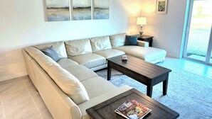 Una sala moderna con un sofá modular, una mesa de centro y un ventilador de techo.