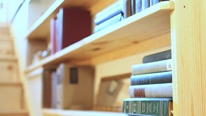 A wooden bookshelf with books and a small plaque. - D. Musee Northeast (Minneapolis)