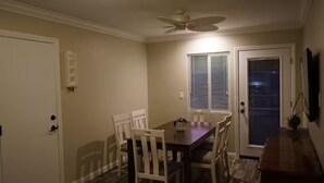 A dining area with a table and chairs, a ceiling fan, and a door with a window. - Terrific 3-bedroom house with AC in sunny Oceanside (Oceanside)