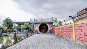 Un sendero lleva a una entrada colorida con un letrero que dice 'SPILL ME'.