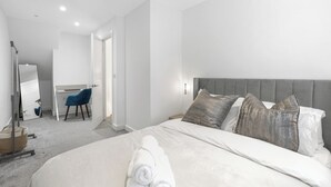 A modern hotel room with a large bed, a desk, and a chair. - Cozy  2-bedroom apartment in Canning Town near Excel London (London)