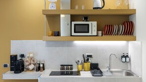 Une cuisine moderne équipée d’un four à micro-ondes encastré, d’une machine à café et d’un évier.