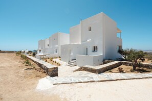A modern white building with a stone pathway and a small tree in the foreground. - Villa THÉA II, Villa THÉA Naxos (Vivlos)
