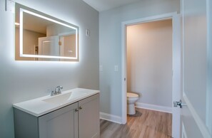 A bathroom with a white sink, a mirror, and a toilet. - New Snowbird 3BR Condo On The Boardwalk + 100 Dollar Resort credit (Myrtle Beach)