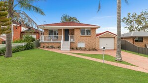 A two-story house with a balcony, a garage, and a well-maintained lawn. - The Pearl by Book Jervis Bay A Fresh, Modern Family Retreat in Old Erowal Bay (Old Erowal Bay)