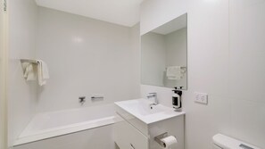 A modern bathroom with a white sink, mirror, and toilet. - Husky Beach Pad by Book Jervis Bay - Couples Retreat (Huskisson)