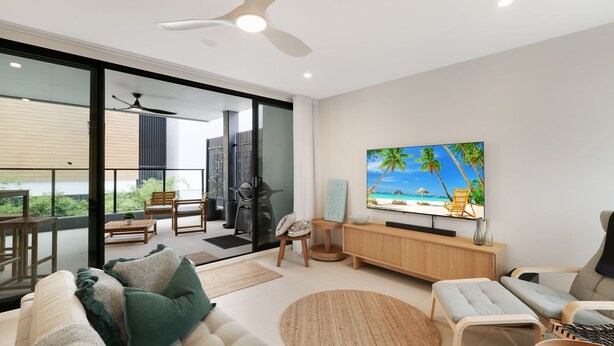 A modern living room with a large flat-screen TV, a sofa, a coffee table, and a balcony with outdoor furniture. - Husky Beach Pad by Book Jervis Bay - Walk to the beach (Huskisson)