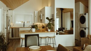 Een moderne keuken met witte kasten, een houten aanrechtblad en een centraal eiland met krukken.