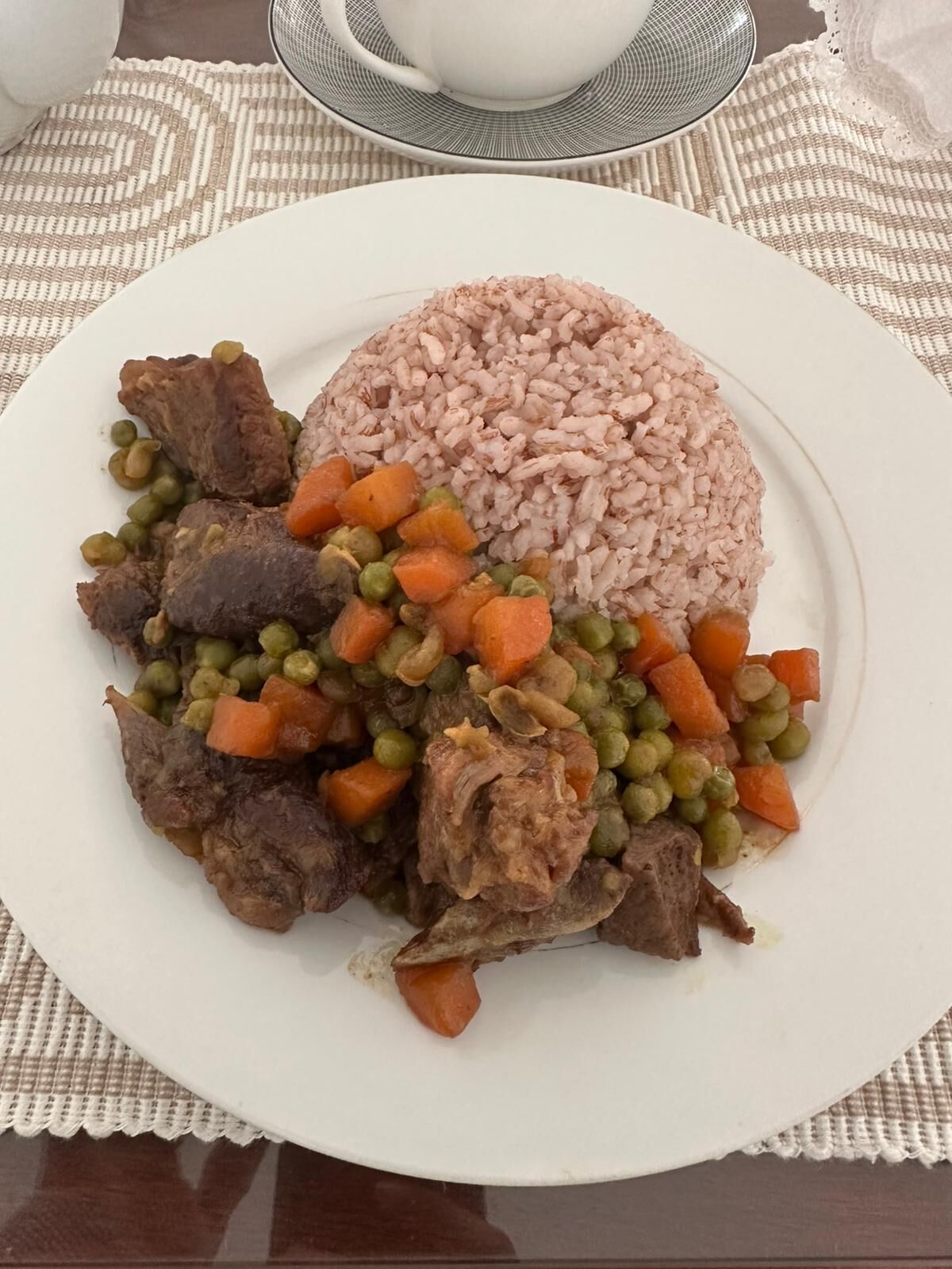 Un plato de comida con arroz, carne y verduras.