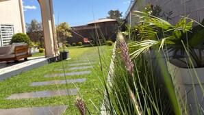 A well-maintained garden with a stone pathway leading to a patio area. - Tia Vahine - Boutique Hôtel Ivato (Antananarivo)
