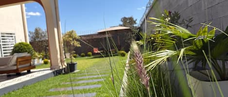 A well-maintained garden with a stone pathway leading to a patio area.