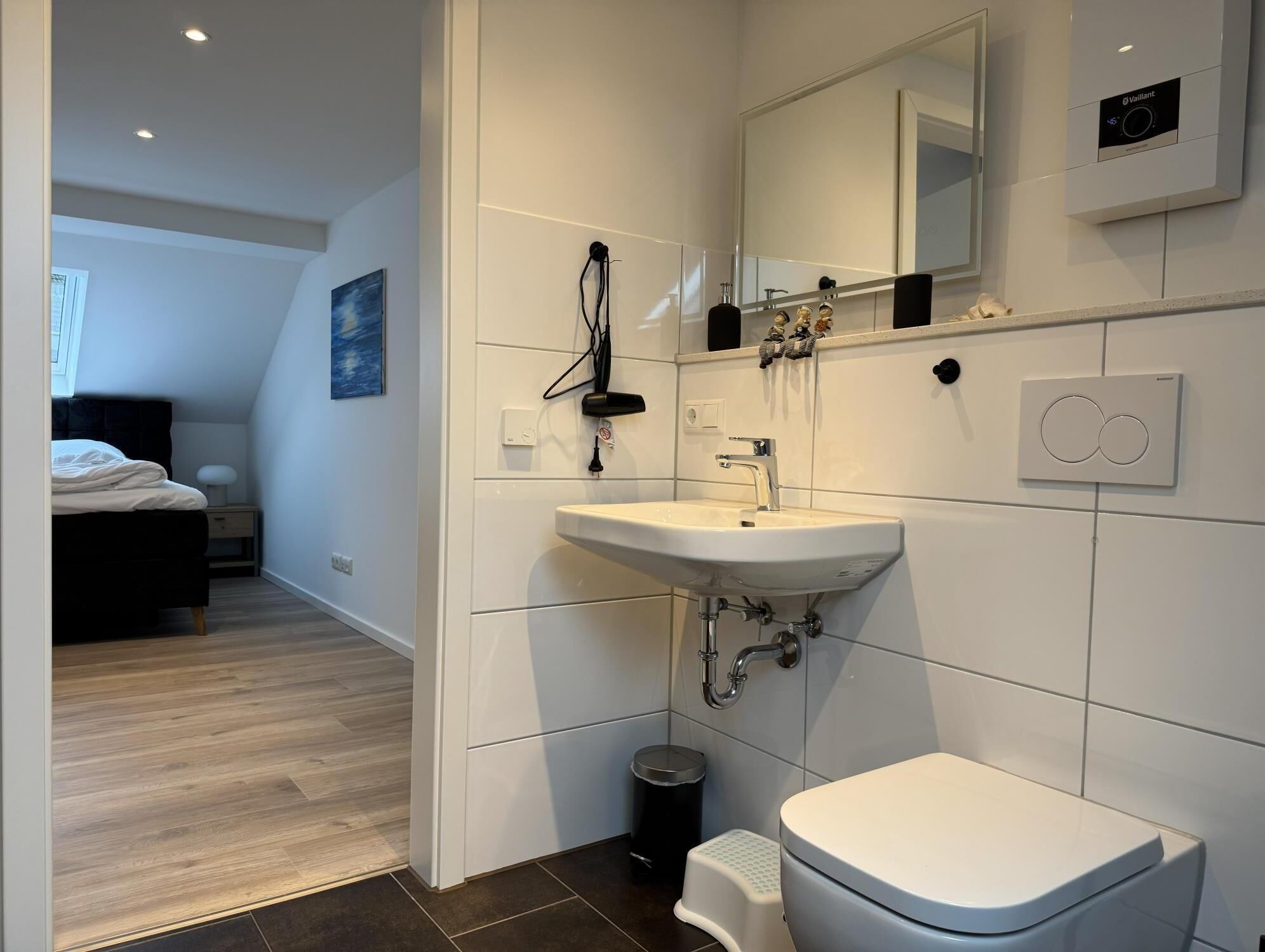 A modern bathroom with a white sink, toilet, and vanity.