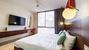 Een moderne hotelkamer met een groot bed, een flatscreen televisie, een nachtkastje en een raam met gordijnen.