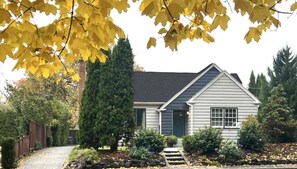 A single-story house with a dark roof, a front porch, and a well-maintained garden. - Black Walnut House @ Pioneer Park + W2 Central (Walla Walla)