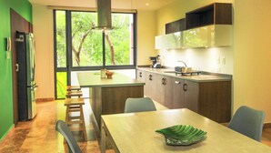 A modern kitchen with a central island, dining table, and chairs. - Mi Querido Tulum Apt with Pool-View (Tulum)