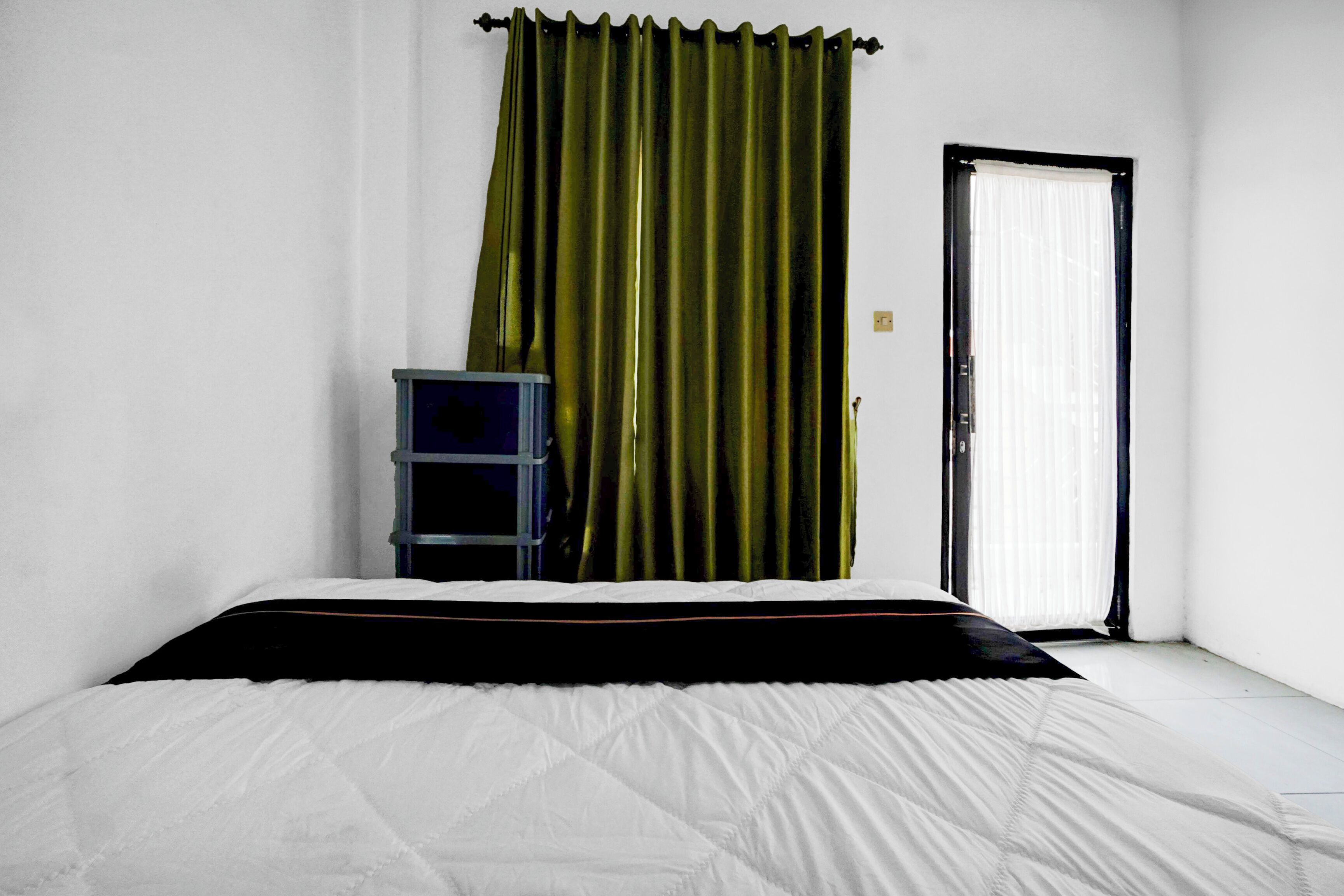 Un dormitorio con cama, armario y puerta.