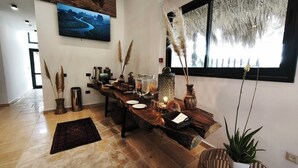 Un espace repas moderne avec une longue table en bois, des objets décoratifs et une grande fenêtre offrant une belle vue.