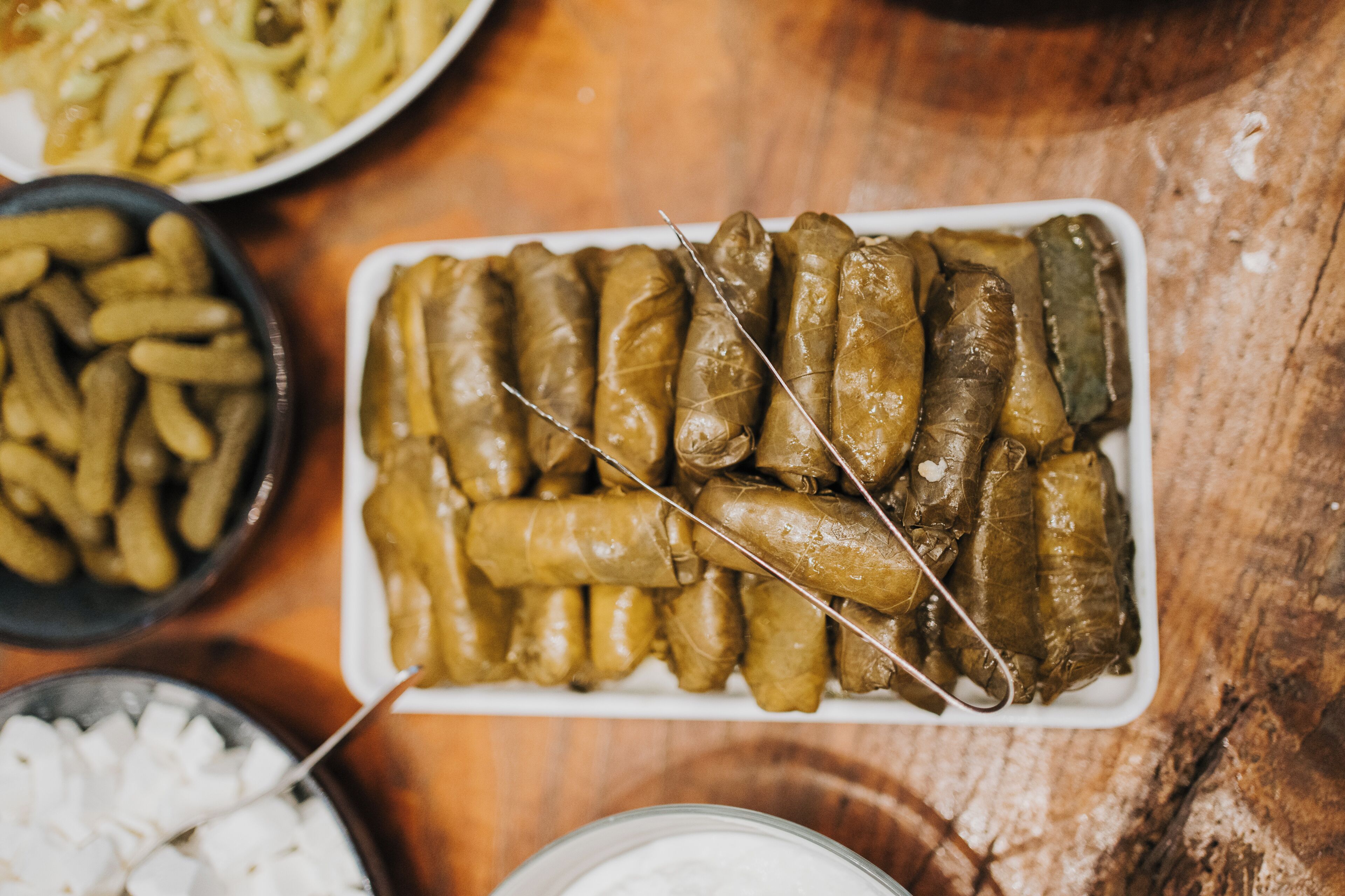 A plate of stuffed grape leaves on a wooden table.
