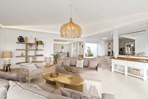 Ein geräumiges Wohnzimmer mit einer großen Couch, einem Couchtisch und einer Pendelleuchte.
