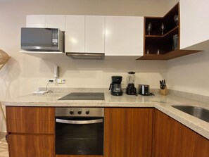 Design appartement | Privékeuken | Een koelkast/vriezer, een magnetron, een oven, een kookplaat