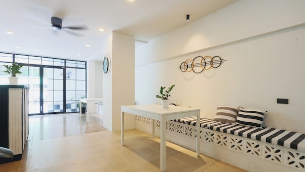 Una sala de estar moderna con un sofá blanco, una mesa blanca y un adorno de pared.