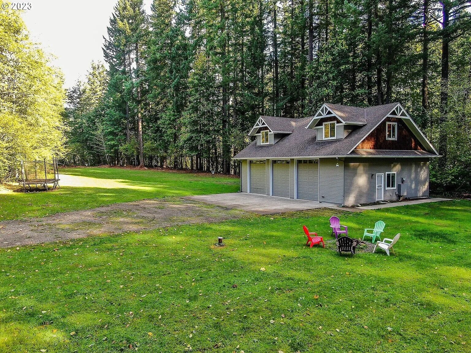 A house with a garage, a lawn, and a swing set.