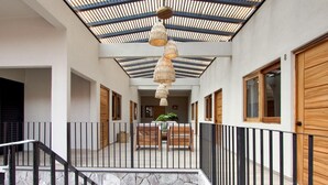A spacious interior with a central seating area, a stone staircase, and a ceiling with a wooden slat design. - Hotel Bravo (Valle de Bravo)
