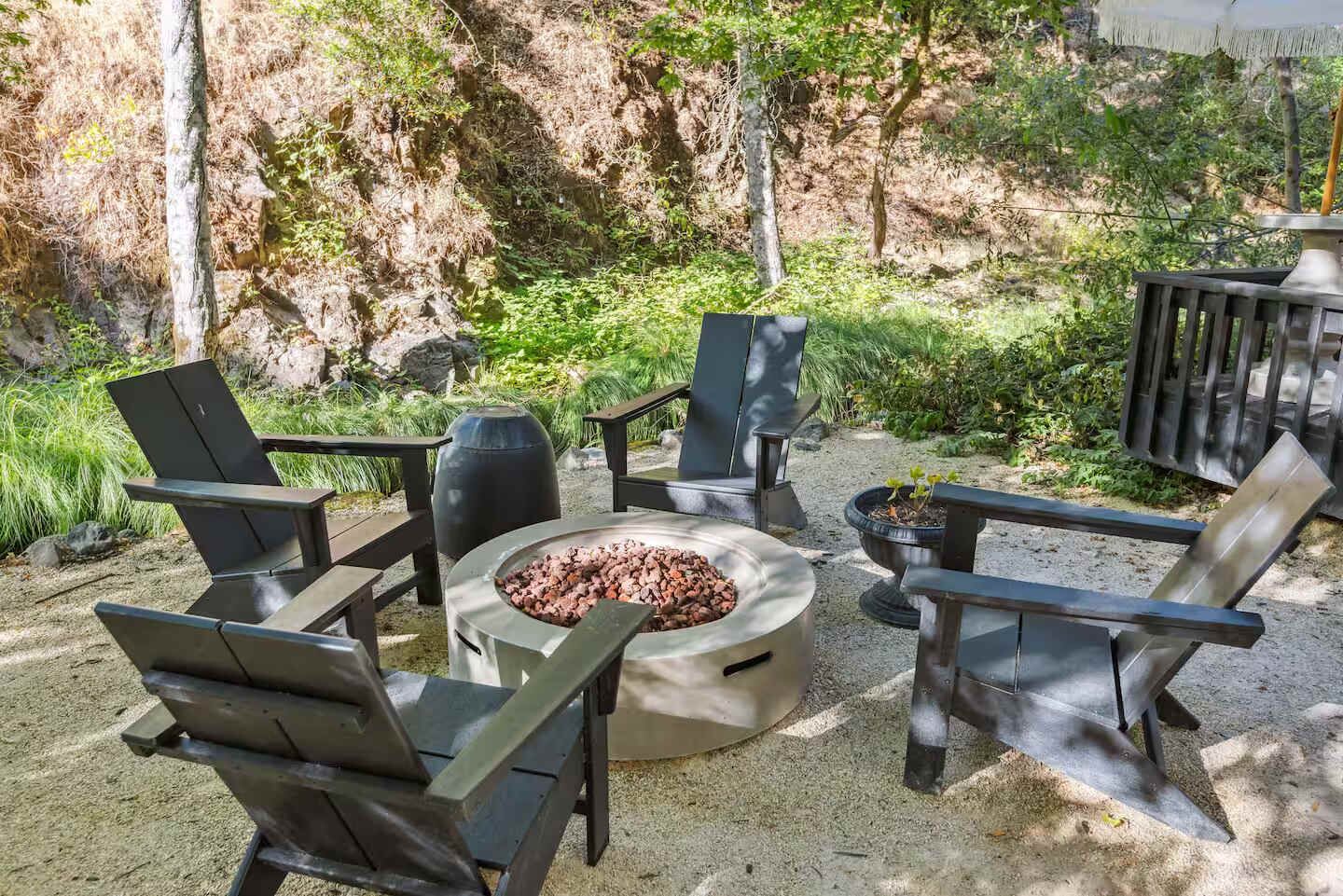 An outdoor seating area with Adirondack chairs and a fire pit.
