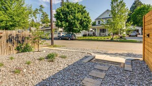 Une rue résidentielle bordée de maisons, avec une clôture en bois et un chemin de gravier.