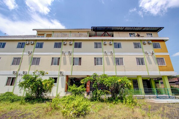 A multi-story building with air conditioning units, a balcony, and a gated entrance. - Collection O near Stadion Manahan (Surakarta)