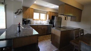 A modern kitchen with granite countertops, stainless steel appliances, and wooden cabinets. - Alpine Retreat - Ski & Golf Across From Hill - Full Townhouse - Fully Stocked (Ellicottville)