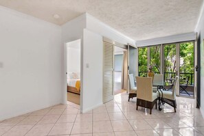 Una habitación amplia con comedor, una cama y vistas a través de amplias ventanas.