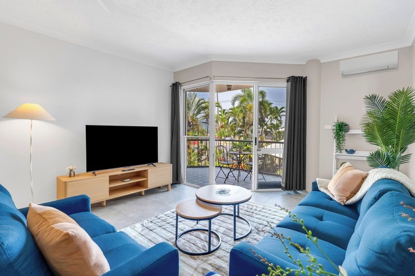 Soft daylight fills this living area, where plush seating, split-system air conditioning and a large-screen TV with Netflix create an easy, welcoming place to unwind.