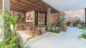 Amplio espacio interior con techo de madera, piscina y diversas opciones de asientos.