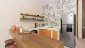 Una cocina moderna con encimera de madera, refrigerador de acero inoxidable y salpicadero decorado.