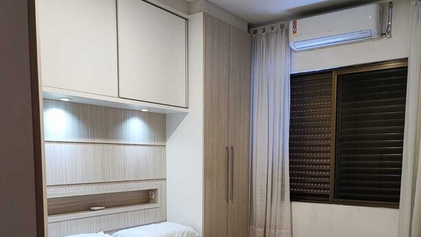 Ein Schlafzimmer mit Bett, Einbauschrank und Klimaanlage.