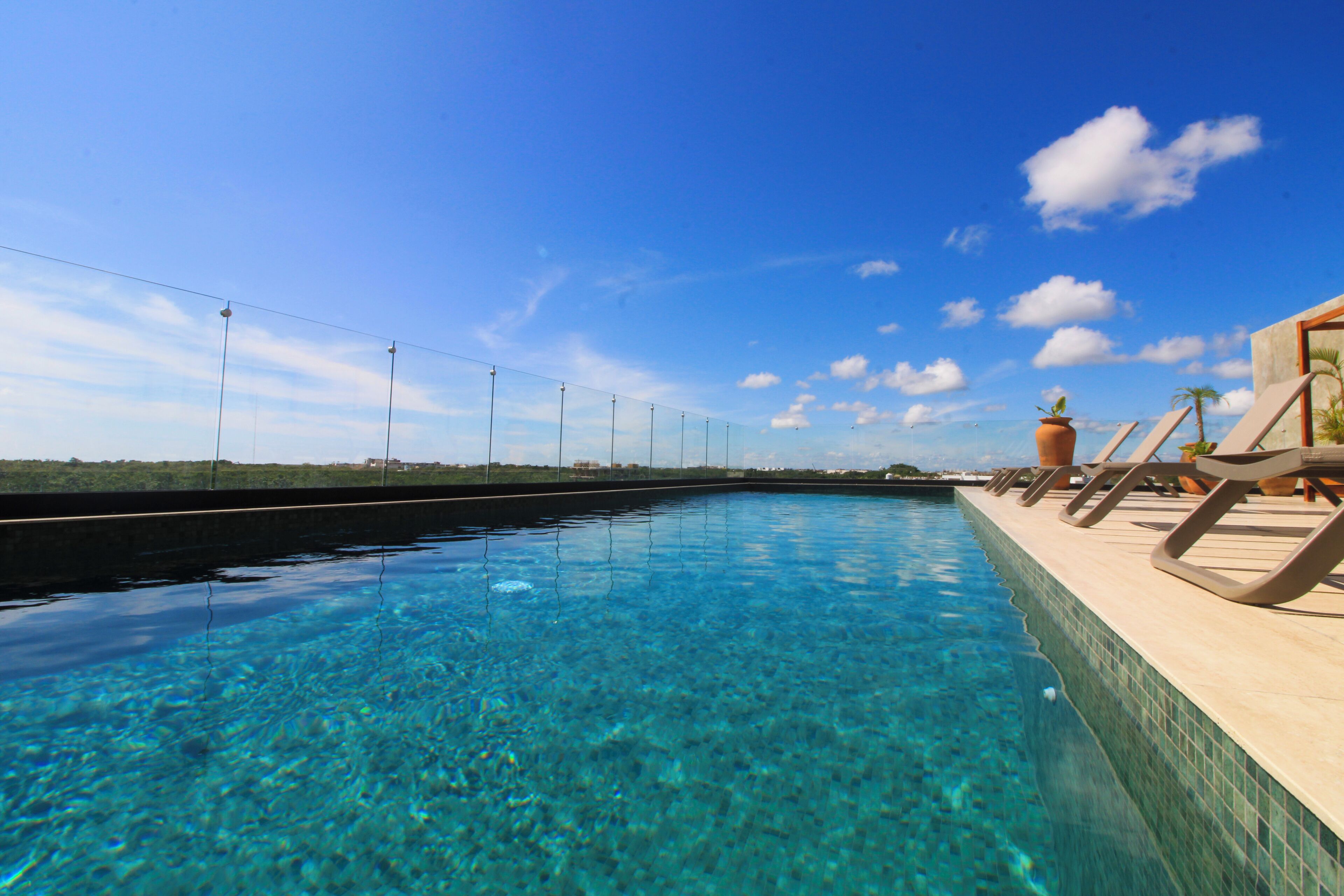 Alberca al aire libre y camastros 