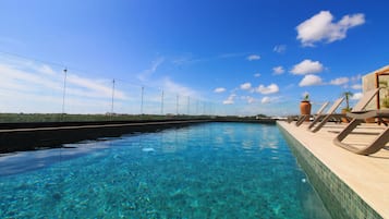 Alberca al aire libre y camastros