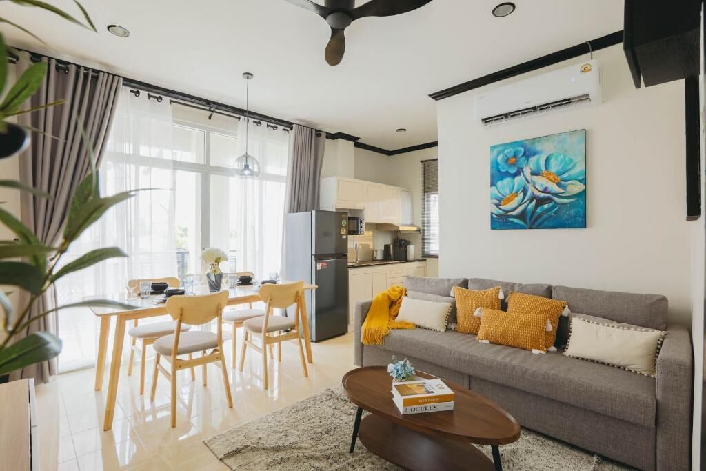 A modern living room with a sofa, coffee table, and dining area.