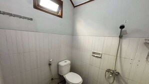 A small bathroom with a toilet, a shower, and a window. - OYO 95050 Penginapan Sekarsari Syariah (Yogyakarta)