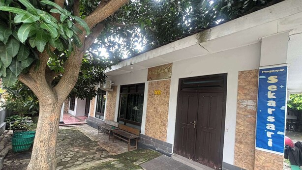 A building with a sign reading "Sekarsari" and a bench outside. - OYO 95050 Penginapan Sekarsari Syariah (Yogyakarta)