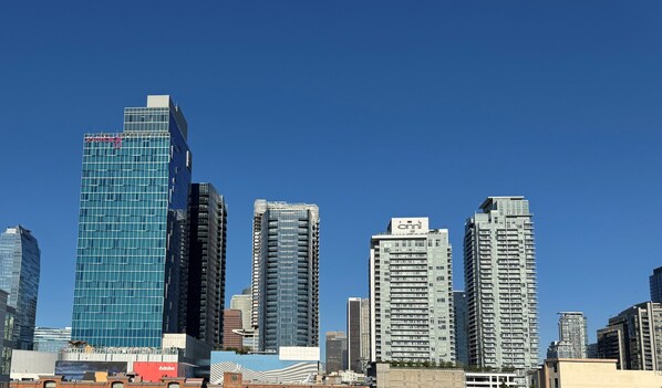 A cityscape with modern high-rise buildings, including a prominent blue glass building and several other high-rise structures.