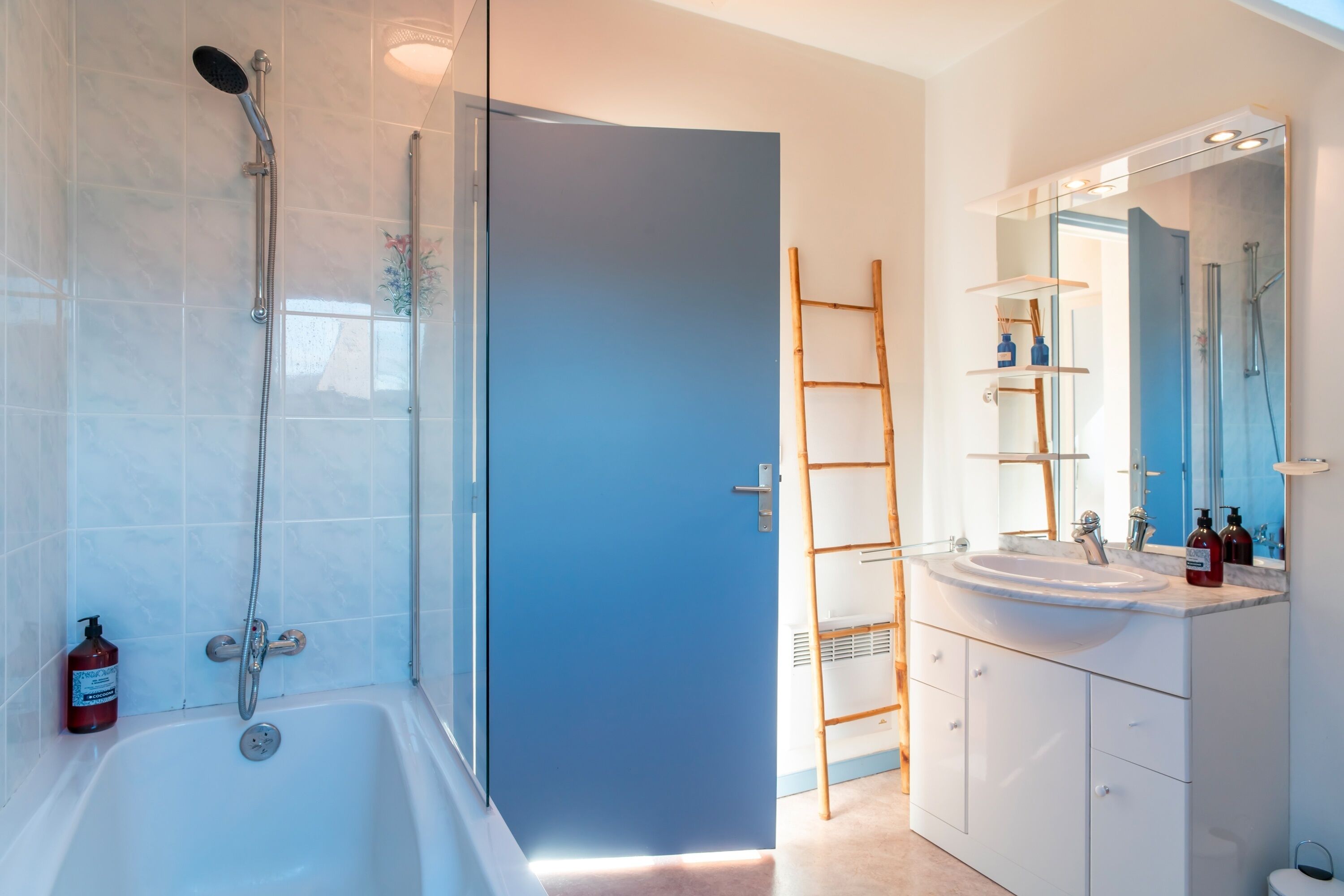 A modern bathroom with a bathtub, shower, and sink.