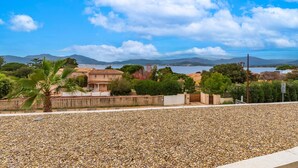 A coastal property with a pebble beach, a palm tree, and a view of the sea and mountains. - A Terrazzo di Calypso - Grande Terrasse (Grosseto-Prugna)
