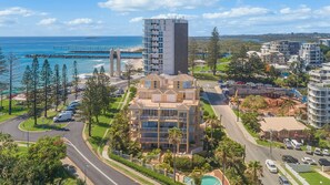 A coastal hotel with multiple floors, a central courtyard, and a view of the ocean and pier. - Orion 3 - Beachfront Rainbow Bay Coolangatta Luxury - Linen Provided - Min. 3 Night Stays (Coolangatta)