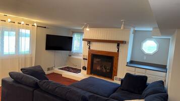 Smart-tv, eldstad, dvd-spelare och ett bordtennisbord