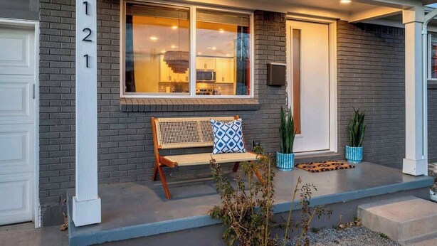 A house with a number '121' on the wall, a bench with a patterned cushion, and potted plants on the porch. - Game Room, Cinema & Fire Pit Backyard (Denver)